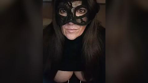 Media: Video of a woman with long brown hair, wearing a black lace masquerade mask and a dark fur coat, looking up with a serene expression.