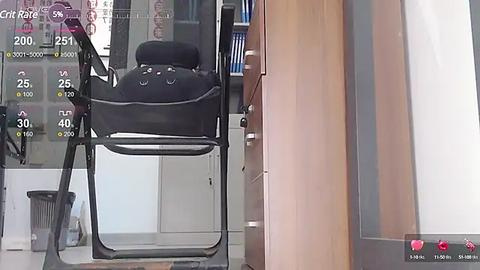 Media: A video shows a black folding chair positioned against a glass door in a modern room, with a wooden cabinet and a white floor visible.