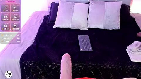 Media: Video of a dark purple bed with white pillows and a grey keyboard, with a large, erect penis visible in the foreground.