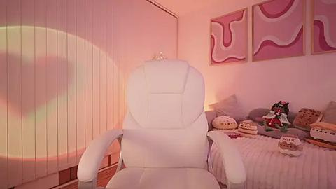 Media: Video of a plush white gaming chair in a cozy, pastel-toned room with pink abstract wall art, plush toys, and a warm, ambient light.