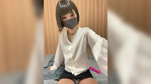 Media: Video of an Asian woman with short, straight black hair, wearing a white blouse, black mask, and black skirt, sitting on a bed with a pink vibrator beside her.