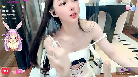 Media: A video of an Asian woman with long black hair and light skin, wearing a white off-shoulder crop top, sitting in a modern office.