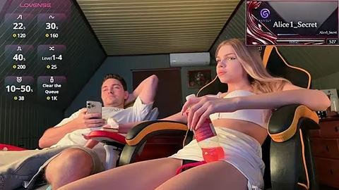 Media: A video of a young couple lounging on gaming chairs, the woman in a white crop top and shorts, the man in a white shirt and shorts, both looking relaxed.