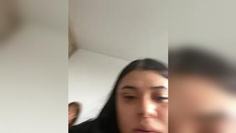 Media: A blurry video of a young woman with long black hair, possibly of South Asian descent, looking confused or upset, with a blurry background.