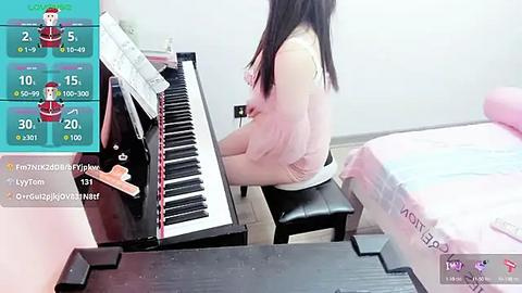 Media: A video of an Asian woman with long black hair, wearing a pink top, playing a digital piano in a bright, minimalist room.