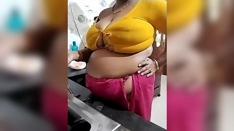 Media: Video of a woman with medium skin tone, wearing a yellow crop top and pink pants, bent over a car trunk, showcasing her large buttocks. Background includes a blurred bathroom scene with a sink and toiletries.