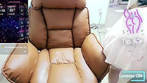 Media: Video of a beige leather recliner with a modern, stylized pink graphic of a heart and arrow on a white dress, alongside a smartphone screen displaying health and fitness data.