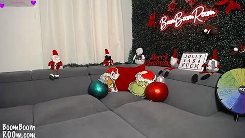 Media: A festive video shows a grey sectional sofa with Christmas decorations, including red and green ornaments, Santa hats, and a colorful disco ball, against a black wall with \"BoomBoom Room\" text.