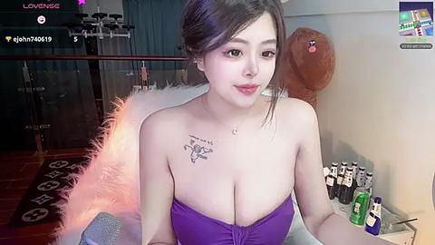 Media: Video of an East Asian woman with fair skin, large breasts, wearing a purple strapless top, sitting on a white furry chair, surrounded by alcohol bottles in a dimly lit room.