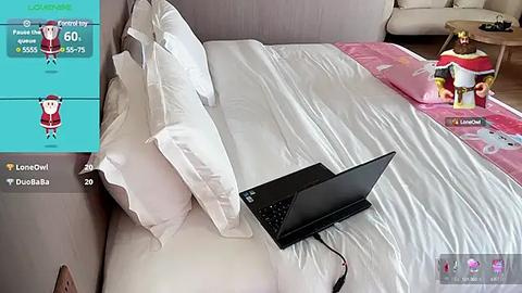 Media: Video of a modern bedroom with a white bed, a laptop on the bed, a stuffed animal, and a teal overlay with social media icons.