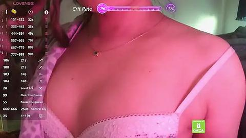 Media: Video of a woman's chest in a white lace bra, wearing a pink top, with a digital overlay showing stats like \"Cup Size\" and \"Fit\" on a pink background.