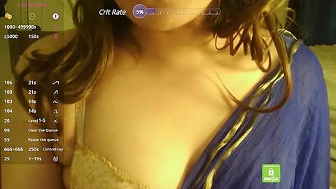 Media: A video of a South Asian woman with medium skin tone and long, wavy brown hair in a blue blouse, partially exposed cleavage, and a hint of a bra.