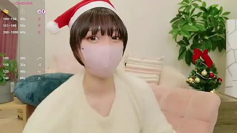 Media: A video of a person wearing a Santa hat and mask, sitting on a couch with a Christmas tree in the background.