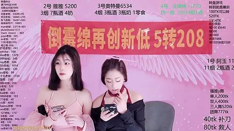 Media: Video of two young East Asian women with straight black hair, wearing pink and black off-shoulder tops, holding smartphones, against a pink background with Chinese text advertising a smartphone.