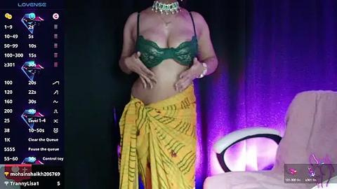 Media: Video of a person in a dark room, wearing a green lace bra and yellow sarong with text, surrounded by streaming platform notifications.