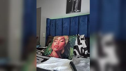 Media: A video of a woman sleeping on a bed with a zebra-patterned comforter. She has light skin, curly hair, and is wearing a green and black-patterned top. The room has a blue headboard and a black-and-white framed picture on the wall.