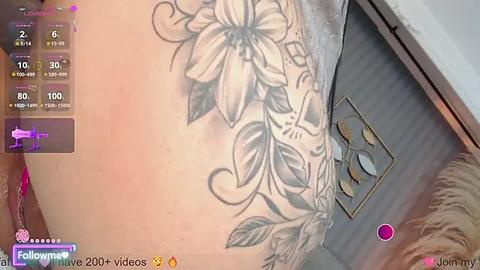 Media: A video of a person's thigh with a detailed black and white lily tattoo on the inner side, taken with a virtual reality headset.