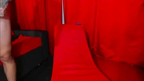 Media: Video of a red cinema seat, with a person partially visible in the background wearing a short-sleeved shirt, and a metallic pole in the upper center.