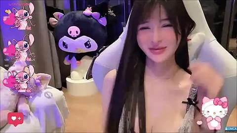 Media: A video of an Asian woman with long black hair, wearing a white lace bra, posing playfully in front of a black cat plushie. Background shows additional plushies, including Hello Kitty, and social media icons.