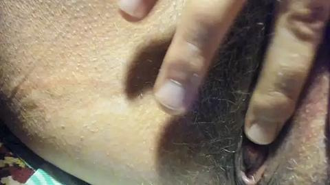 Media: Video of a close-up view of a person's shaved pubic area, with a hand gently touching the skin, showing light skin tone and visible hair follicles.