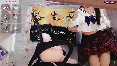 Media: Video of an Asian woman in a Halloween-themed schoolgirl outfit, holding a pumpkin, next to a pumpkin-decorated window.