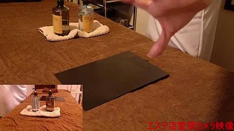 Media: Video of a person using a black iPad on a brown, textured wooden table. A beige coaster holds two bottles of wine. A hand is in motion near the iPad.