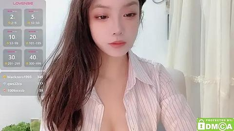 Media: A video of an Asian woman with long brown hair, fair skin, and light makeup, wearing a partially unbuttoned striped shirt, indoors, with a calendar and stats overlay.