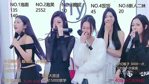 Media: Video of four East Asian women, each holding a microphone, singing into it against a white background with Chinese text and numbers. They wear black and white outfits.