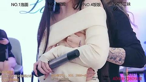 Media: Video of a woman in a white sweater, with a man's arm around her, tattoos on her arm, blurred background, Chinese text, and date stamp.