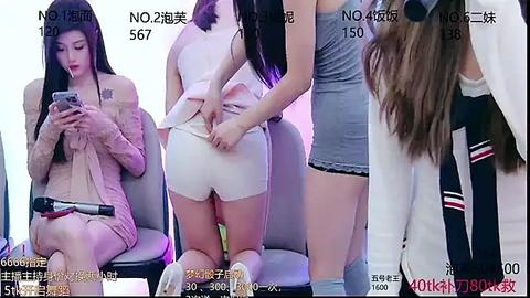 Media: Video of three Asian women in a modern setting, one adjusting another's white shorts, another wearing a beige dress, and a third in a white top and shorts.