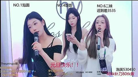 Media: Video of three young Asian women, each with long black hair, wearing black dresses, holding microphones, singing into them, with Chinese text overlaid.