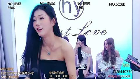 Media: Video of a live broadcast featuring a smiling East Asian woman with long black hair, wearing a strapless black dress, against a blue and white backdrop with Chinese text.