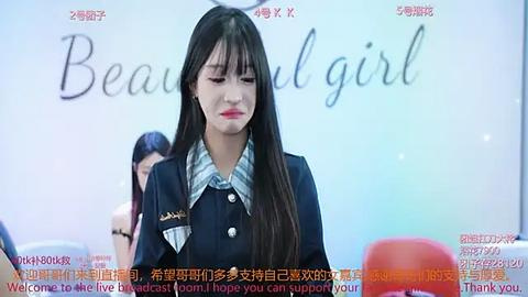 Media: Video of a young East Asian woman with long black hair, dressed in a navy blue school uniform, standing in front of a whiteboard with \"Beautiful girl\" written in Chinese characters.