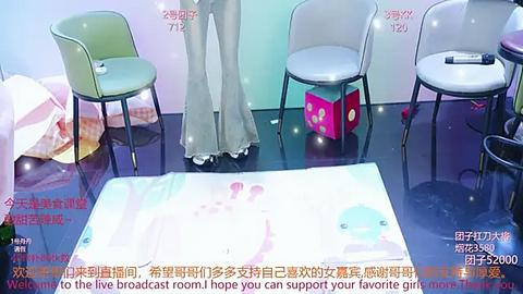 Media: Video of a modern, minimalist room with a large white table, three pastel-colored chairs, and a pink box. The floor is glossy, and Chinese text is overlaid on the image.