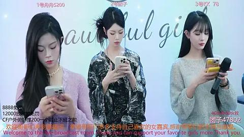 Media: Video of three young East Asian women with pale skin, long black hair, and varying clothing styles, looking at smartphones against a pastel background.