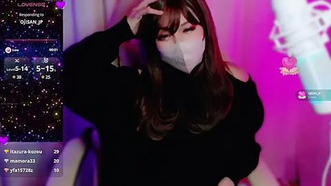 Media: Video of an East Asian woman with long brown hair, wearing a black sweater and face mask, against a pink and purple background, showing a live streaming overlay.