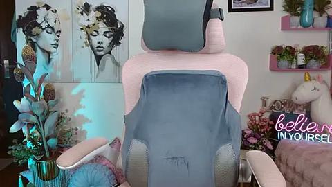 Media: Video of a pink and blue baby chair with a matching pillow and stuffed unicorn toy in a whimsical, floral-themed nursery.