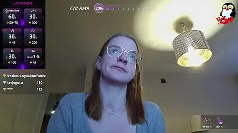 Media: Video of a young woman with light skin, glasses, and brown hair, smiling in a dimly lit room with a chandelier. Live stream overlay shows chat messages and stats.