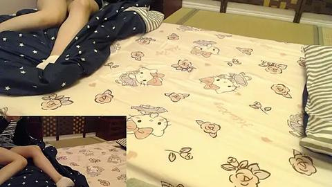 Media: Video of a woman in a dark blue nightgown with white polka dots lying on a bed with a Hello Kitty-themed comforter.