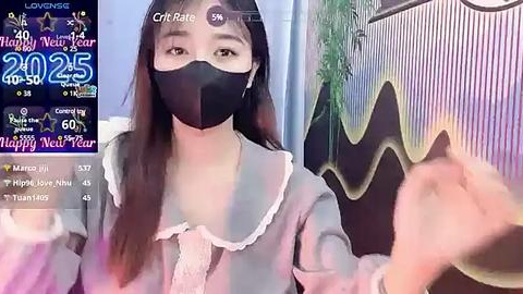 Media: Video of an East Asian woman in a black mask, grey dress, with a live stream overlay displaying COVID-19 statistics.