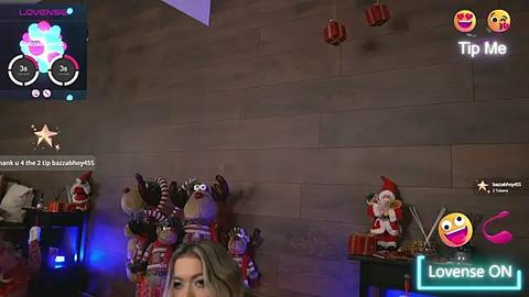 Media: Video of a woman with blonde hair wearing a festive elf hat, surrounded by Christmas decorations and virtual elements in a cozy living room.