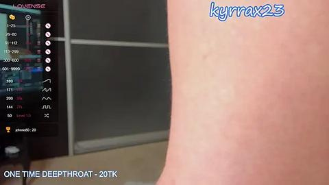 Media: Video of a close-up, fair-skinned human forearm with a tattoo of \"Kymmax23\" in blue ink. Background shows a blurred, modern room with a TV displaying a video game interface. Text reads \"One Time Deepthroat 2018TK.\