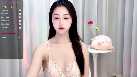 Media: A video of an Asian woman with long black hair, wearing a pale pink lace bra, standing in front of a pink piggy bank and white curtains, with a virtual dating app interface in the background.