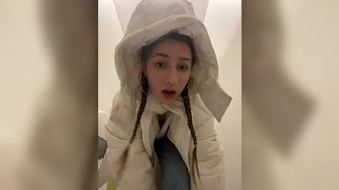 Media: A video of a person wearing a white, furry costume resembling a rabbit, with long braids, against a blurred background. The person's expression is serious and focused.