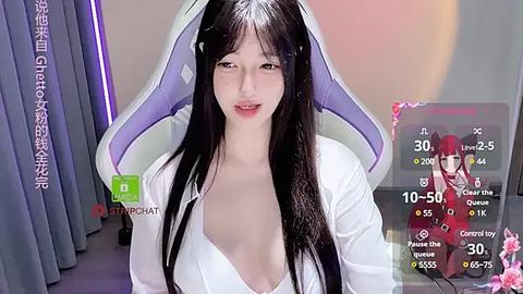 Media: Video of an East Asian woman with long black hair, wearing a white hoodie, posing seductively in a gaming chair.