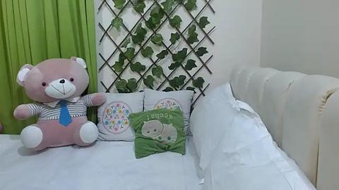 Media: A video of a cozy baby nursery with a white crib, a green curtain, a teddy bear, and decorative pillows featuring cartoon animals and a \"Goodnight Moon\" print.