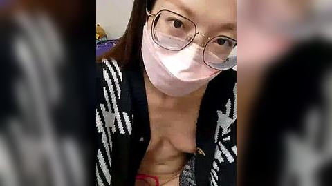 Media: Video of a young Asian woman with light skin, wearing glasses and a mask, revealing her bare breasts in a black and white checkered cardigan.