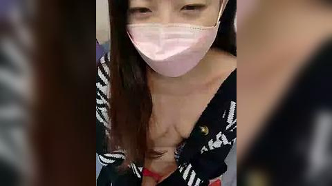 Media: Video of an Asian woman with long brown hair, wearing a pink surgical mask, black patterned top, and red bra visible.