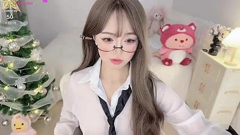 Media: Video of an East Asian woman with long brown hair and glasses, wearing a white shirt, black tie, and black necktie, in a cozy, Christmas-themed bedroom.