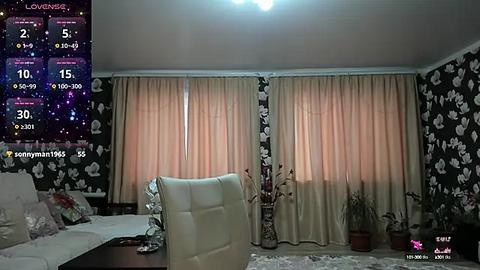 Media: A video of a cozy, modern living room with white curtains, floral wallpaper, a white leather couch, and a white leather chair.